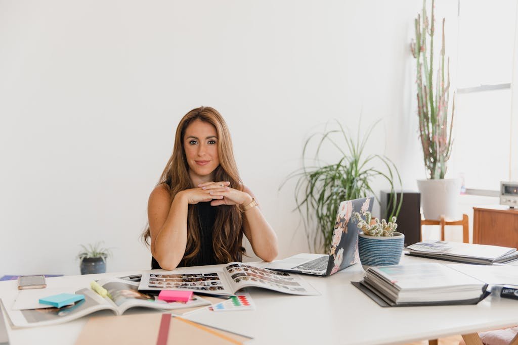 Businesswoman in stylish office with laptop and documents, showcasing a professional work environment.